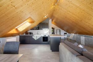 a kitchen and living room with a wooden ceiling at Bergliebe in Bitz