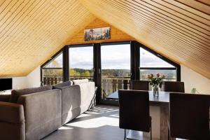 a living room with couches and a table and windows at Bergliebe in Bitz