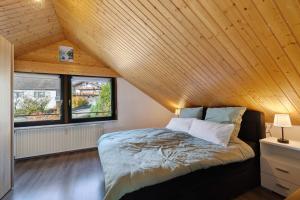 a bed in a room with a wooden ceiling at Bergliebe in Bitz
