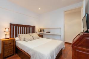 a bedroom with a large white bed with a television at Maria Beach in Platja d'Aro