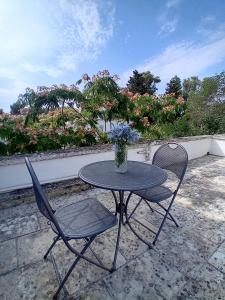 a table and chairs with a vase on a patio at Sud e Sole in Lecce +14 photos