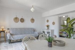 a living room with a couch and a table and chairs at Syrios Suites No 2 in Kalymnos