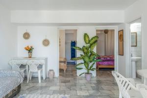 a living room with a bed and a table and a plant at Syrios Suites No 2 in Kalymnos