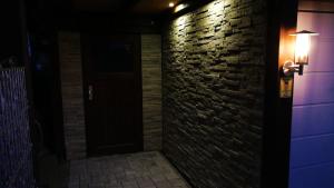 a brick wall with a light next to a door at Ferienwohnung am Silberg in Plettenberg
