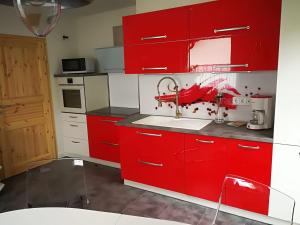 a kitchen with red cabinets and a sink at Ferienwohnung am Silberg in Plettenberg