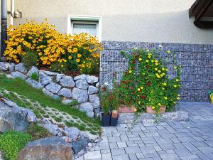a garden with flowers and a stone wall at Ferienwohnung am Silberg in Plettenberg