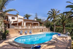 a house with a swimming pool and palm trees at Sembat de Mar in Cala Millor