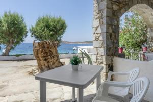 a table and chairs on a patio near the water at Syrios Suites No 2 in Kalymnos