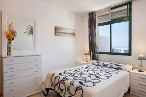 a bedroom with a bed and a window and a dresser at Balcón de Amadores - Beach view in Puerto Rico de Gran Canaria +14 photos