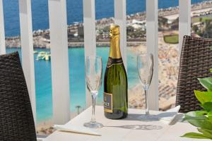 a bottle of champagne sitting on a table with two wine glasses at Balcón de Amadores - Beach view in Puerto Rico de Gran Canaria