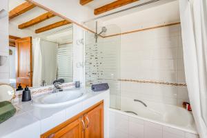 a bathroom with a sink and a tub and a mirror at Casa Agnès in Mahón +13 photos