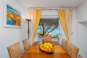 a dining room table with a bowl of fruit on it at Bella Vista Marinella 1 in Olbia