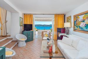 a living room with a white couch and a table at Bella Vista Marinella 1 in Olbia