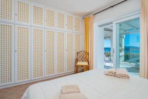 a bedroom with a white bed and a balcony at Bella Vista Marinella 1 in Olbia