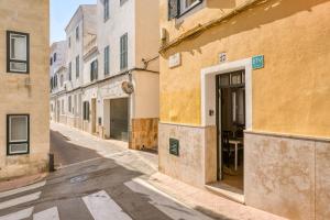 an empty street in an alley with buildings at Casa Agnès in Mahón