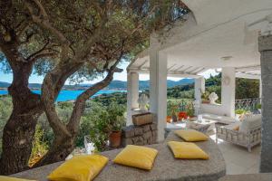 a house with two pillows on a porch with a tree at Bella Vista Marinella 1 in Olbia