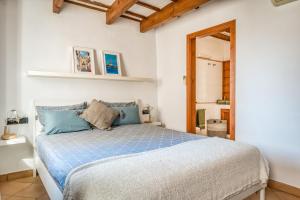 a bedroom with a bed with blue pillows at Casa Agnès in Mahón