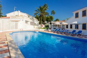 a swimming pool in front of a house at Marlena in Cala en Bosc