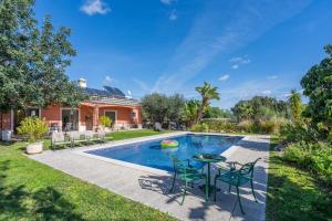 a pool with chairs and a table next to a house at Quinta Dos 4 Ventos in Silves