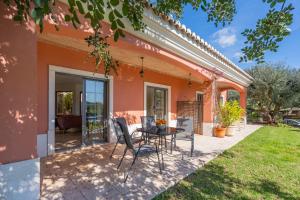 a patio with a table and chairs in front of a house at Quinta Dos 4 Ventos in Silves