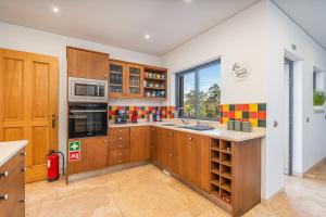 a kitchen with wooden cabinets and a sink at Quinta Dos 4 Ventos in Silves