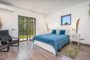 a bedroom with a king sized bed and a chair at Quinta Dos 4 Ventos in Silves +37 photos