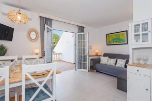 a living room with a couch and a table at Marlena in Cala en Bosc