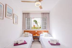 a room with two beds and a window at Marlena in Cala en Bosc +15 photos
