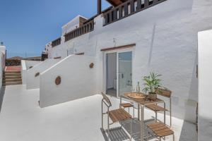 a white house with a table and chairs on a balcony at Rincón De Agustín in Mácher