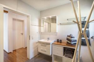 a white bathroom with a sink and a mirror at Ferienwohnung s'Raubers in Bühlertal +31 photos
