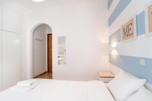 a white bedroom with a bed and a table at Livadia Seaside Studios 13 in Parikia