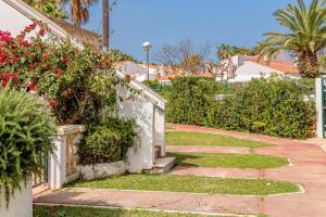 a walkway leading to a house with flowers at Marlena in Cala en Bosc