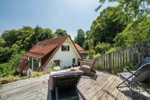 a wooden deck with chairs and a house at Ferienwohnung s'Raubers in Bühlertal
