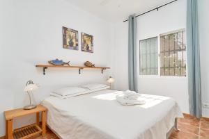 a white bedroom with a bed and a window at Villa Amapola in Caserío Carraspite +27 photos