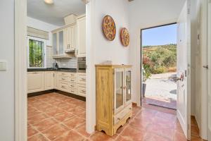 a kitchen with white cabinets and a large window at Villa Amapola in Caserío Carraspite