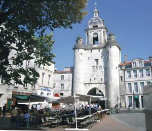 a building with a tower with a clock on it at Maison Sulz in Montendre