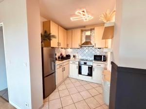 a kitchen with white cabinets and a stainless steel refrigerator at Apartment Kokorey in Halstenbek +8 photos