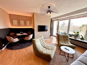 a living room with a couch and a table and chairs at Apartment Kokorey in Halstenbek
