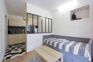 a small bedroom with a bed and a table at Charmant studio 2 in Courchevel