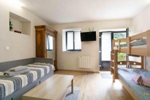 a bedroom with two bunk beds and a tv at Charmant studio 2 in Courchevel