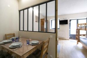 a dining room with a table with plates on it at Charmant studio 2 in Courchevel