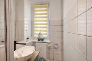 a white bathroom with a sink and a window at Ferienwohnung San Marino 3 in Mücheln +13 photos
