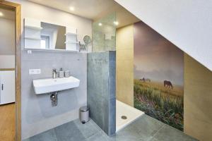 a bathroom with a sink and a painting on the wall at Haus Auergang Schmallenberg in Schmallenberg +11 photos