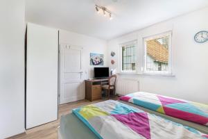 a bedroom with a bed and a desk and a window at Edos Private Zimmervermietung in Birstein