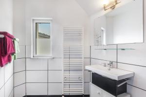 a white bathroom with a sink and a mirror at Edos Private Zimmervermietung in Birstein +36 photos