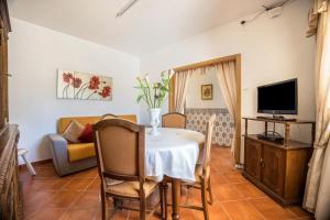 a living room with a table and a tv at Casa Fernandes in Burgau