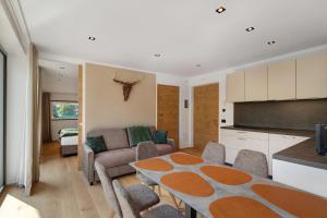 a kitchen and living room with a table and a couch at Premium App Hofer Silena in Villabassa