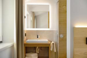 a bathroom with a sink and a mirror at Premium App Hofer Silena in Villabassa +25 photos