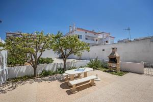 a patio with a table and a stove at Casa Fernandes in Burgau