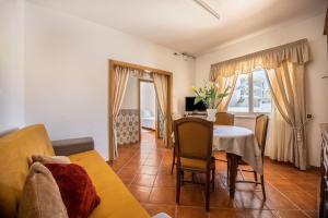a living room with a table and a dining room at Casa Fernandes in Burgau